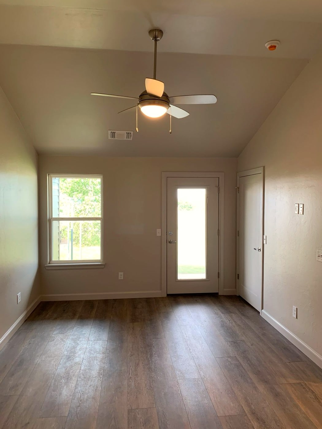 Bedroom with ceiling fan and glass door to the patio