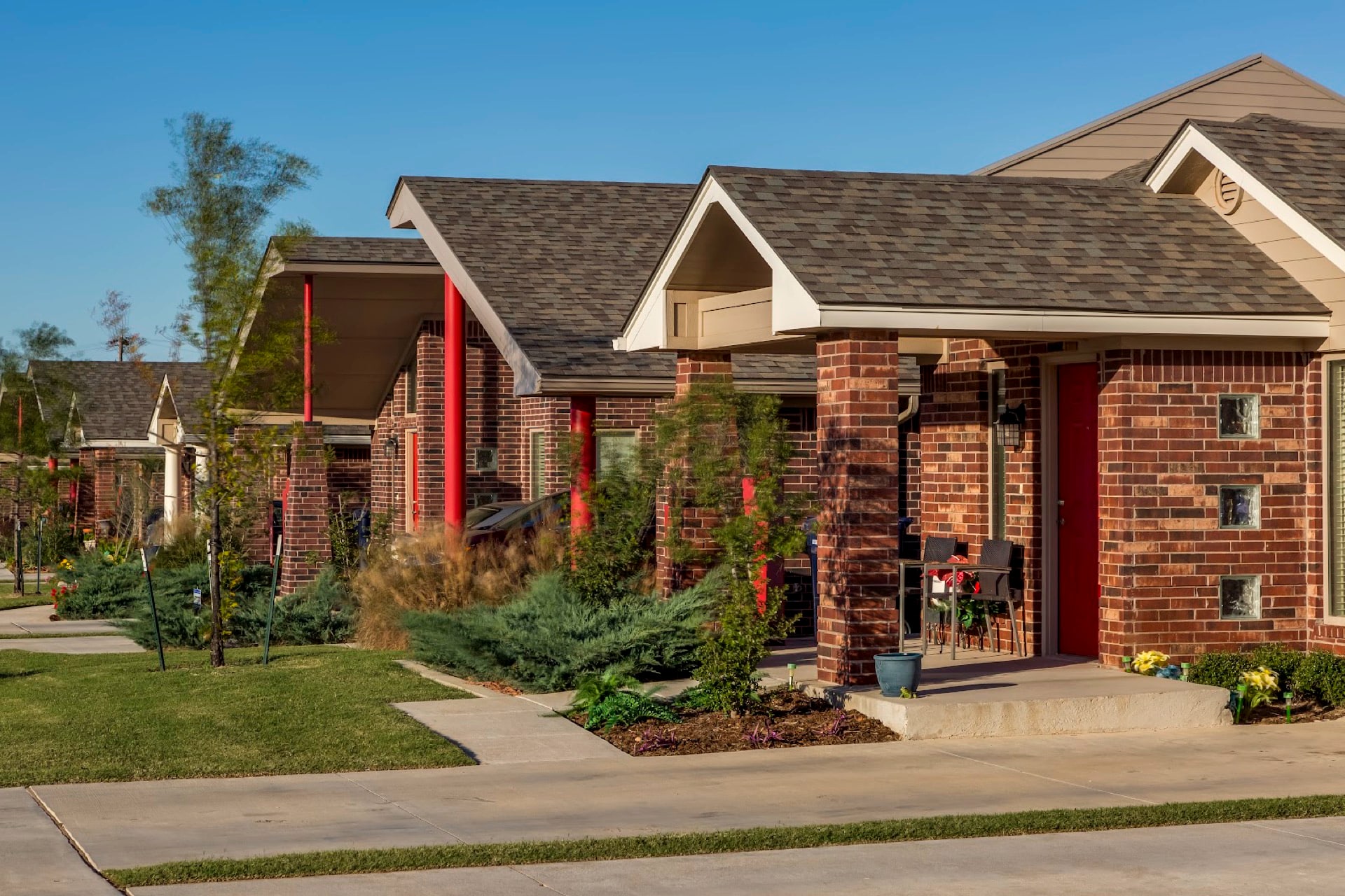 A row of brick Forest Village duplex porches along a quiet street
